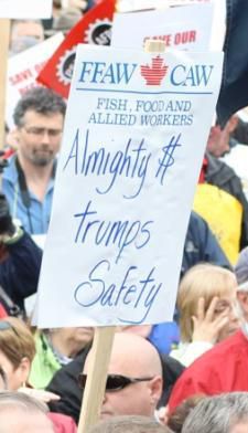 Banners and placards read: “Canada is Not for Sale!”, “Our Safety is Not for Sale!,” “Almighty Dollar Trumps Safety,” “Come Fishing With Me, Harper,” “Harper, Out to Destroy Newfoundland,” and “Shame on You Harper!”