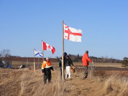 Hardy souls on a COLD day plant Mi'kmaq, Canadian, and Nova Scotia flags at the river discharge site.