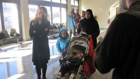 Fakhira Chaudhry and her two youngest children wait with community supporters as her husband speaks to the media. (Photo: Tom MacDonald)