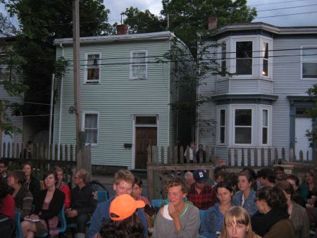 The audience gathers in the Fuller Terrace backyard.