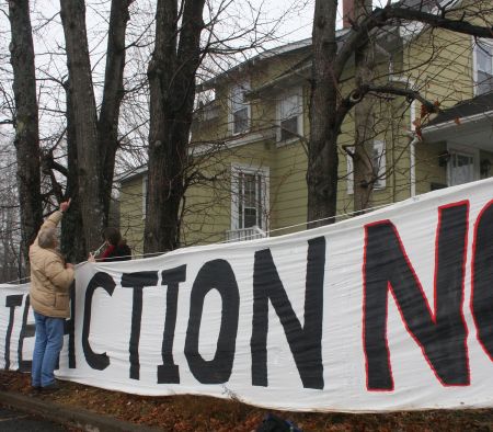 Volunteers help string up a 'Climate Action Now' banner.