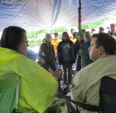 Alma Brooks, a Maliseet elder and Kirk MacDonald, the York North MLA, speak in a meeting at the blockade of seismic vibrators in Stanley, NB. Photo: Tracy Glynn.