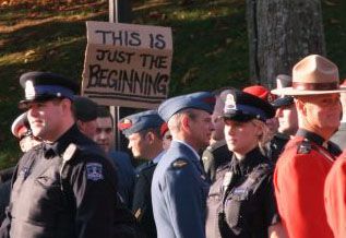 A protester holds up a sign during a military memorial that took place in Parade Square on the second day of the occupation.  So far, police have not attempted to remove occupiers from the site.   Photo: Miles Howe