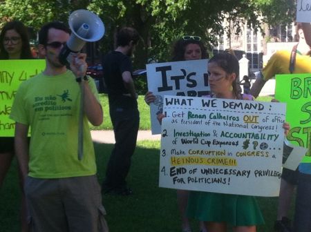 Igor Santos addresses passersby with a list of demands for the Brazilian government. Photo Jon Grant