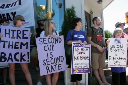 Supporters holding signs listen as Kinder speaks. (Photo by Hilary Beaumont)