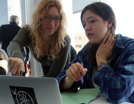 On Saturday, Feb 14, members of Stop The Energy East Pipeline Halifax hosted a pizza party, at which citizens opposed to the pipeline could get help filling out an application to intervene on the project. Stop The Energy East Pipeline Halifax member and event organizer Kiki Wood (left) is shown helping Olivia Bochenek with her application. [Zack Metcalfe photo]