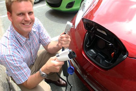 Professor of mechanical engineering Lukas Swan is shown in front of his fully electric Nissan Leaf, showing off its charging mechanisms. All electric vehicles can plug into your standard outlet, but will charge more slowly than if they are attached to specialized chargers which can be installed at home our found in public locations across the country.  Zack Metcalfe photo