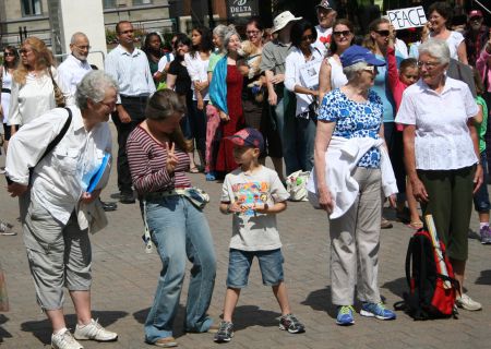 Kelly B. Schnare, 31, teaches six-year-old William Lorincz about hand signs as they help form a human peace symbol in the Grand Parade.