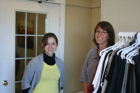 Melody Aalders and Beth Easson of Community Inc. in Kentville. Melody will be laid off on March 31st.  This will affect people with disabilities who have a job or are looking for one. (The clothes in the foreground are free to people who need to look their best at an interview or on the job). Photo Robert Devet