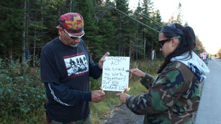 Jim Pictou and Suzanne Patles, of the Mi'kmaq Warriors Society, light up a representation of the Indian Act. [Photo: E. Knockwood]