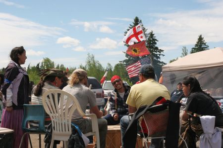 Drumming in the sun at the sacred fire on highway 126. [Photo: M. Howe]