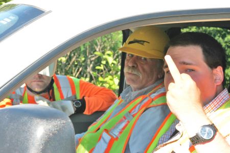 Class Acts: Driver gives camera the bird after passenger threatens to run child over. [Photo: M. Howe]