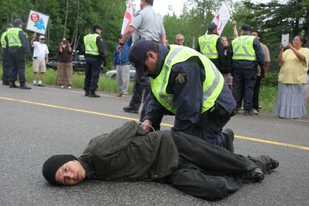 Segewaat, who has been tending the sacred fire for over a week, was among the first to be arrested [Photo: M. Howe]