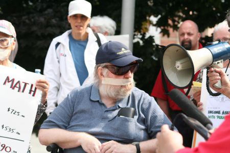 Poverty activist Wayne MacNaughton was gagged to symbolize the sense that government isn't listening. Photo Robert Devet 