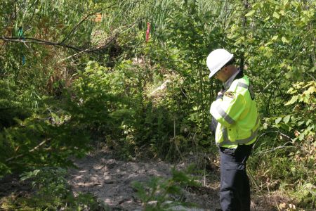 Security guard prays for Mother Nature at the site of a wetlands shot-hole. [Photo: Miles Howe]