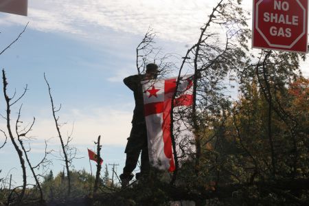 Young Mi'gmaw Warrior raises Mi'gmaw flag [Photo: M. Howe]