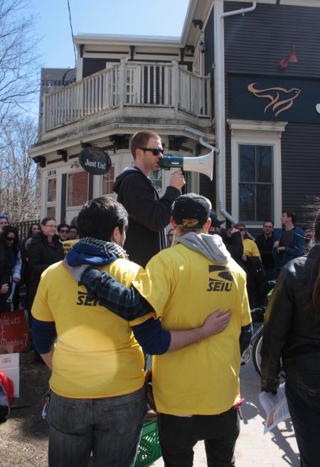 Elijah Williams, left, and Shay Enxuga, right, listen as Jason Edwards speaks to the crowd. (Photo by Hilary Beaumont.)