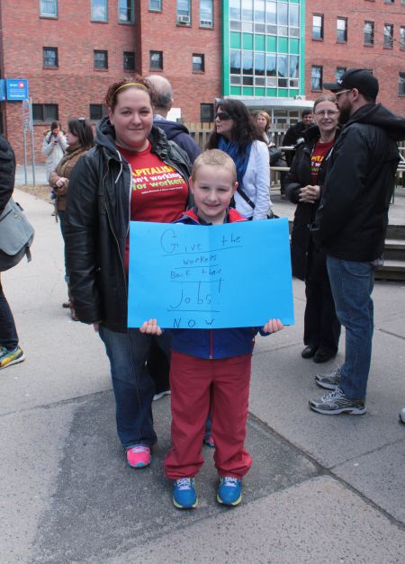 Lucas Hantling holds a sign he made in support of the "dismissed" workers. (Photo by Hilary Beaumont.)