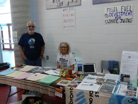 Kathryn Anderson and Wilf Bean, members of Mining the Connections, at an information table at the General Council in Corner Brook, NL. [Photo: Ann Russell]