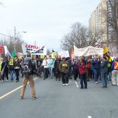 A diverse group of people march together.