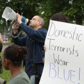 Isaac Saney, a Dalhousie faculty member, yells into the megaphone (Photo: Hilary Beaumont)