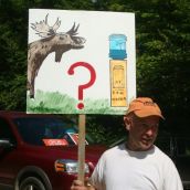 A man draws attention to the impacts of shale gas activity on water and wildlife with his sign at the blockade of seismic vibrators in Stanley. Photo: Carla Gunn. 