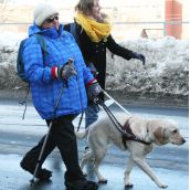 Organizer Kaleigh Trace assists a vision-impaired participant in the rally.