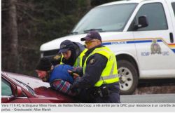 Photo by Allan Marsh, published by Acadie Nouvelle, of journalist Miles Howe being arrested in New Brunswick.